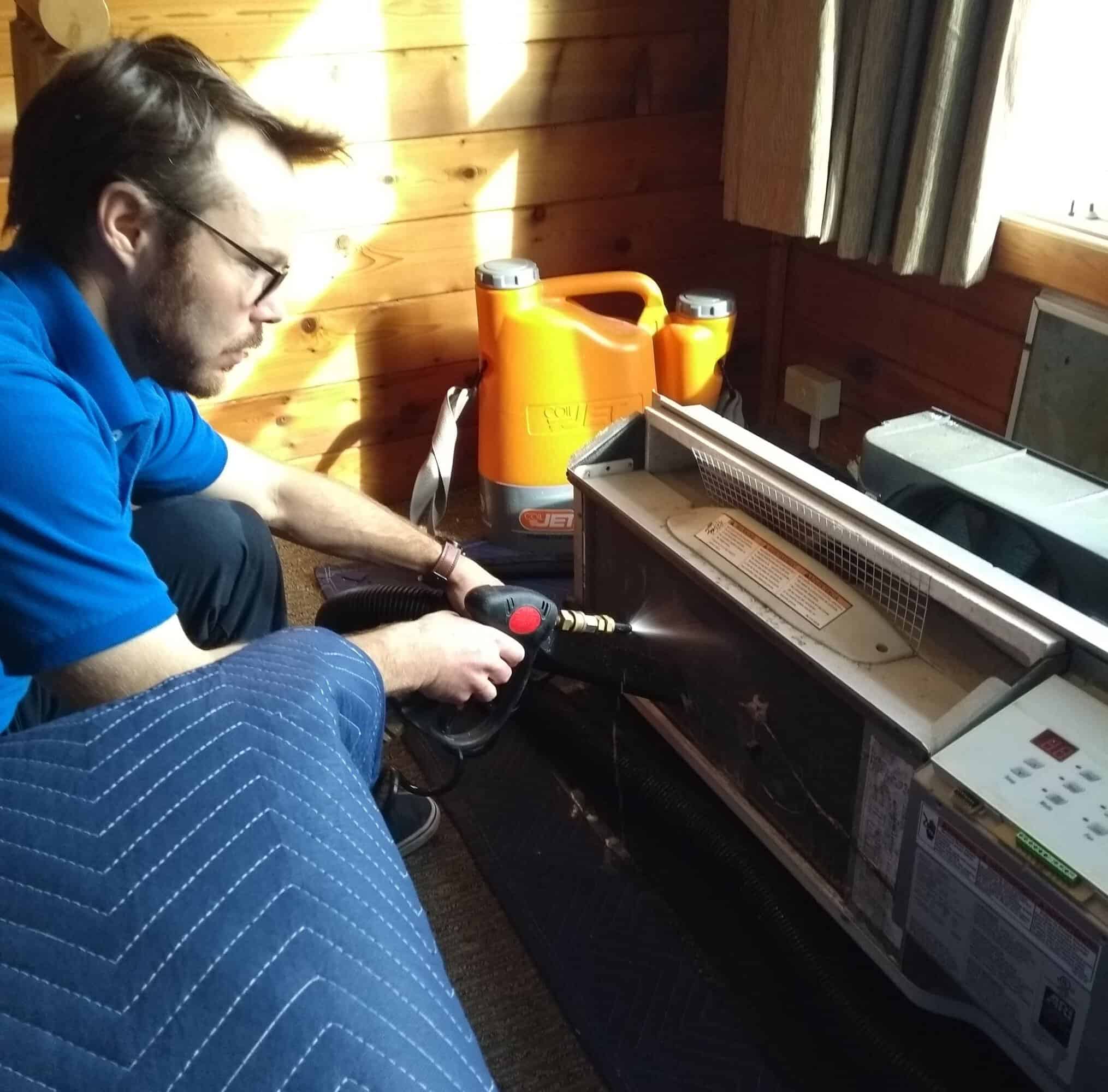 Heat pump cleaning technician servicing mini-split unit in Nova Scotia home
