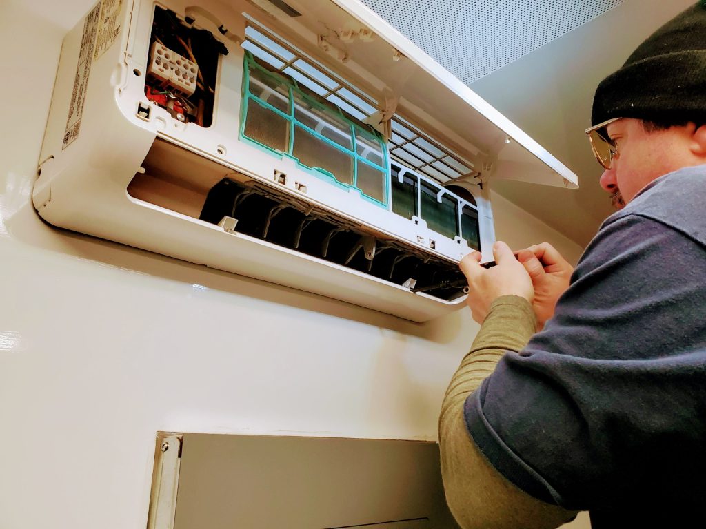 Heat pump technician inspecting mini-split Inverness County Cabot Trail Nova Scotia